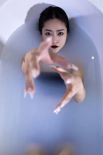 一个漂浮在浴缸里的女人 双手在水中