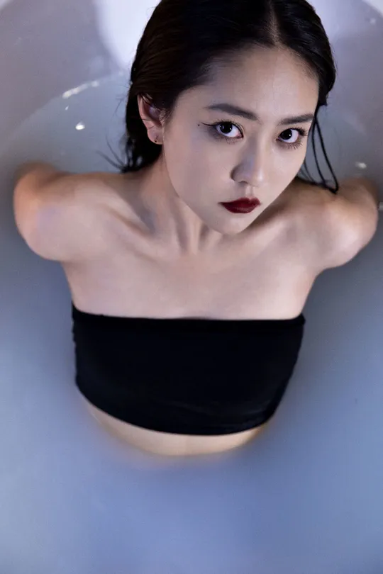 一个穿黑色衣服的女人在一个带有马桶的浴缸中