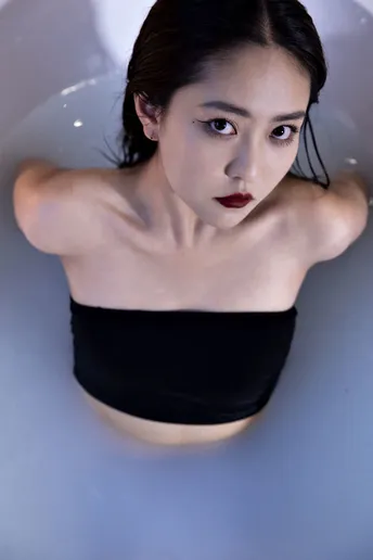 一个穿黑色衣服的女人在一个带有马桶的浴缸中