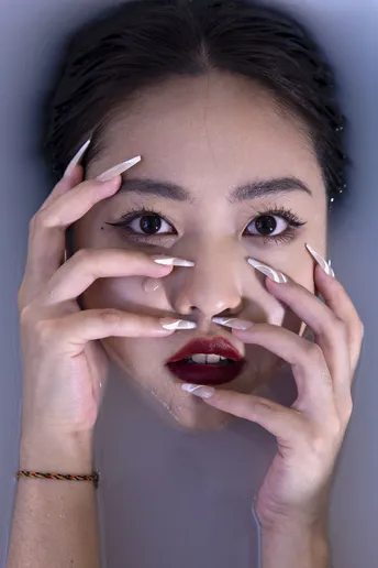 一位女士 手上有白指甲 手里拿着一支烟