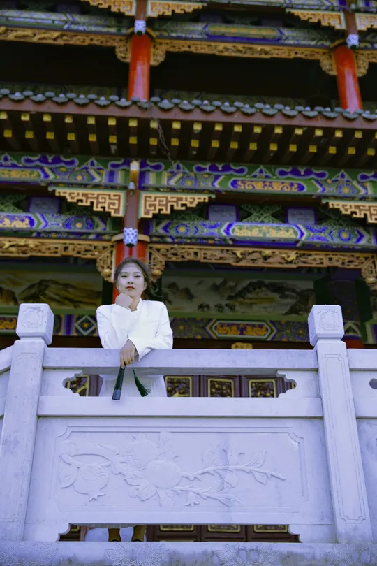 一位坐在白色建筑前的女人 站在寺庙前