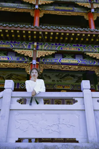 一位坐在白色建筑前的女人 站在寺庙前