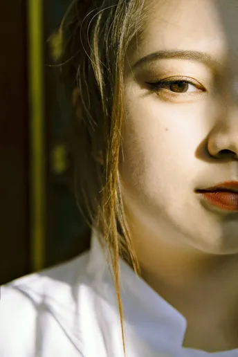 一位年轻女子穿着白色衬衫和领带 正对着相机。