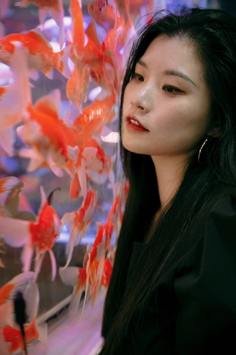 一个年轻女子在鱼缸里看金鱼