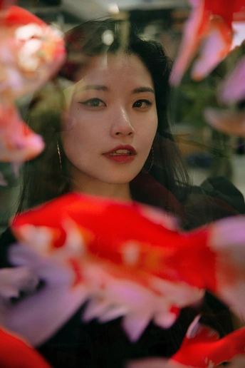 镜子里看红鱼的一个年轻女子