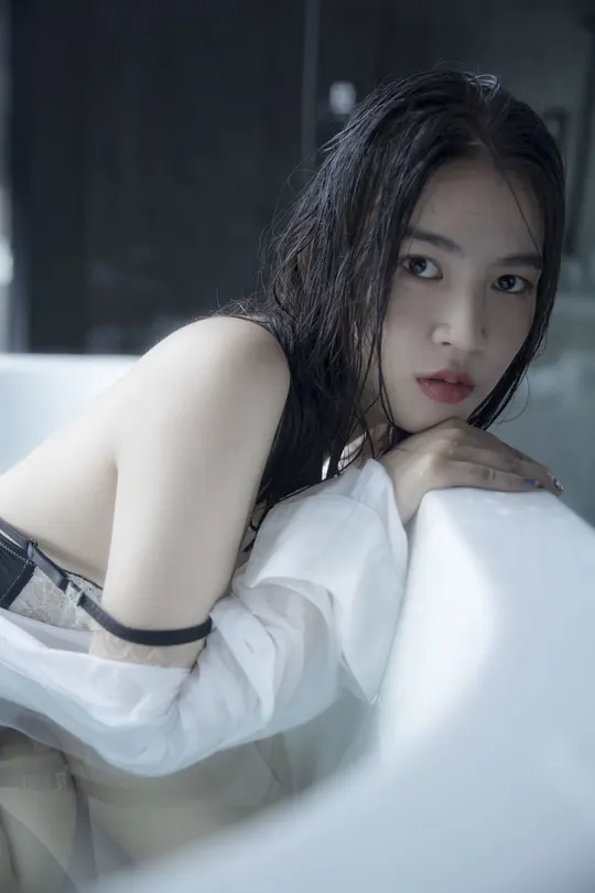 一个年轻女子坐在浴缸里洗浴间