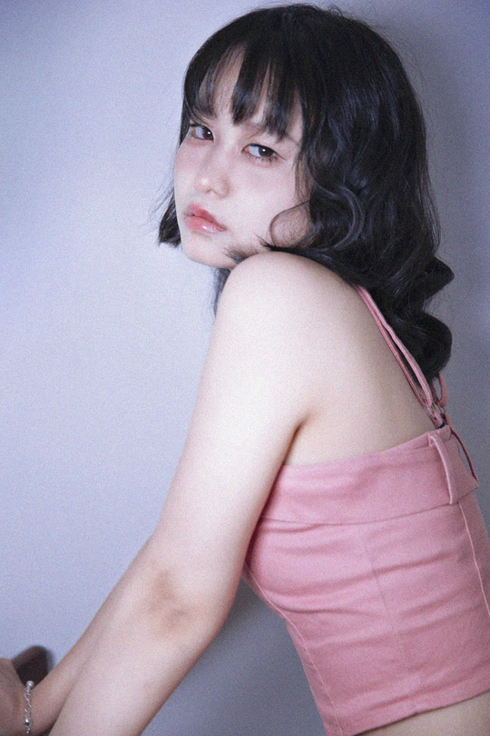 一位穿着粉红色连衣裙的年轻女子右手握着一把刀。