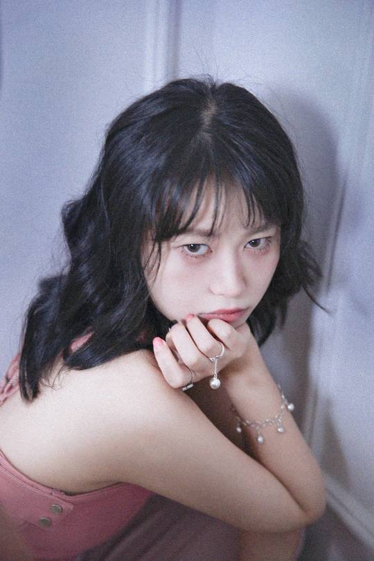 一个年轻女子坐在墙上 手托下巴