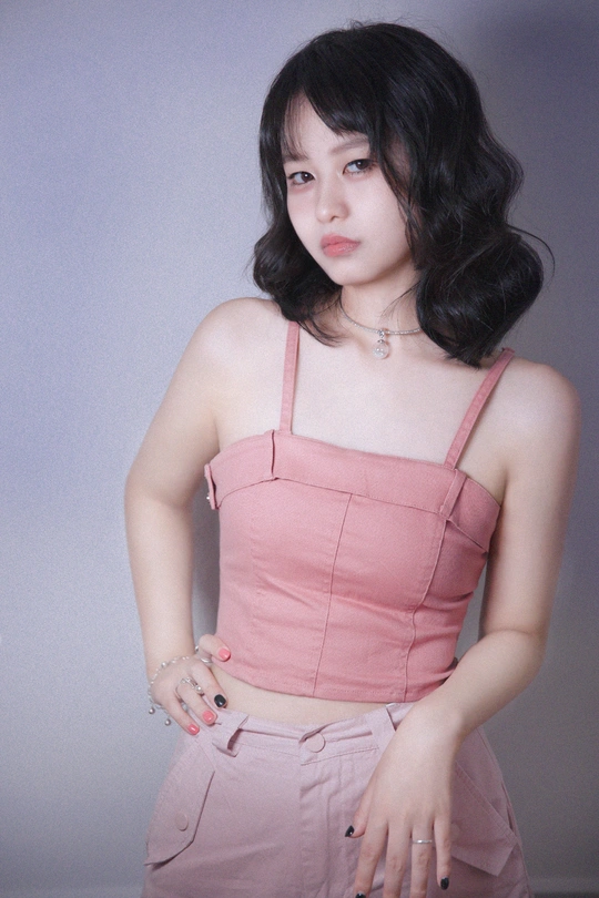 一位穿着粉红色连衣裙的年轻女子正在摆姿势