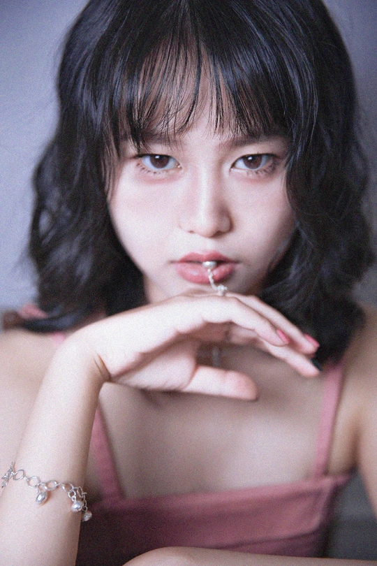 一位穿着粉红色连衣裙 手里拿着一支烟的年轻女子