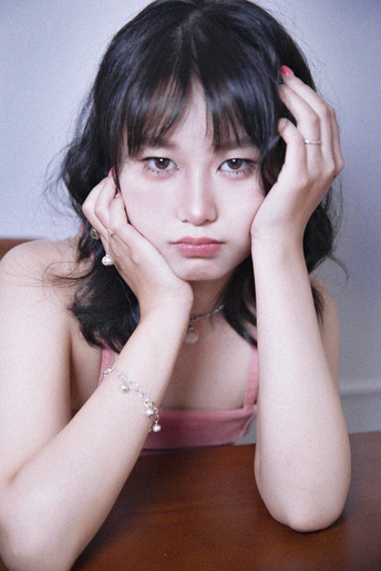 一个年轻女子坐在桌子旁 手托下巴 头靠在手上