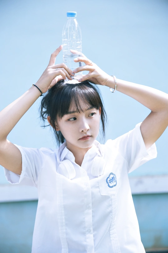 一位穿着制服的年轻女子头顶一瓶水