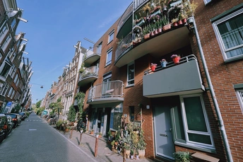 一条街道 两侧是公寓楼 楼台上盛开着鲜花。