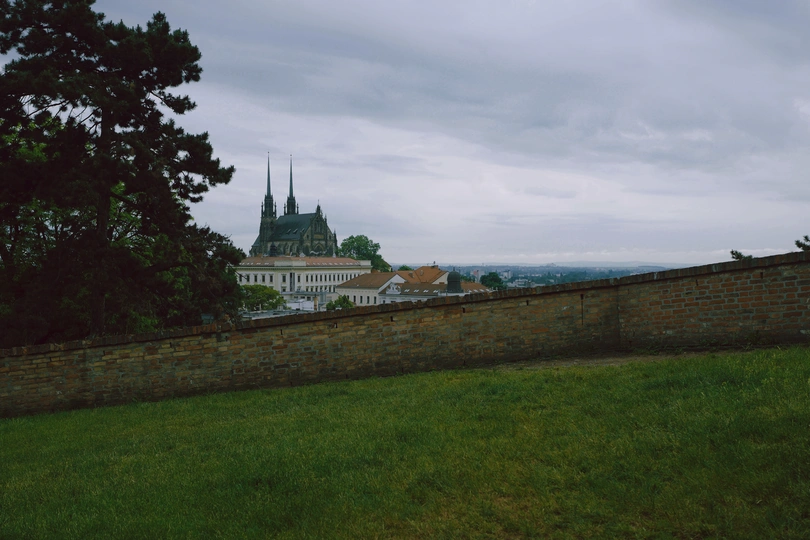 山顶上的城堡 草地是绿色的 前景是砖墙。
