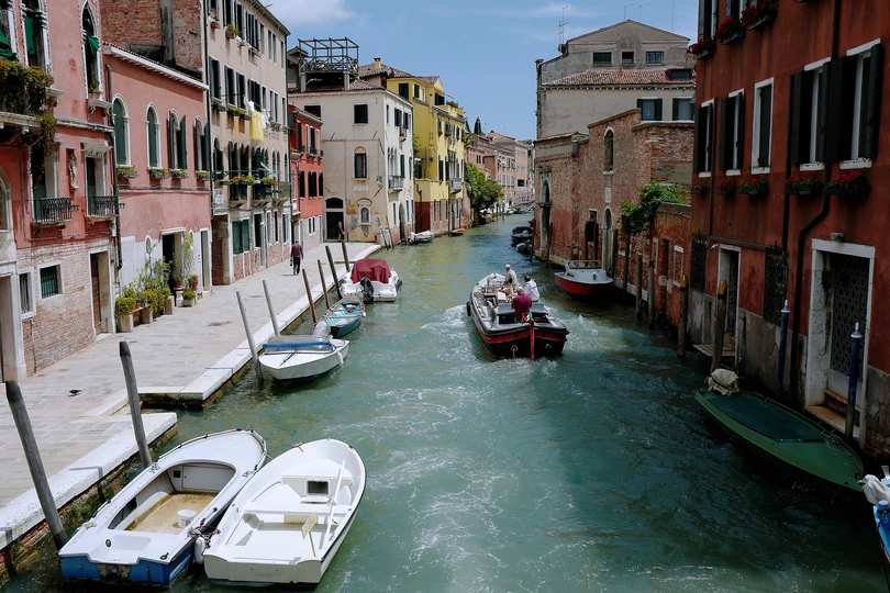 城市中的狭窄运河 有许多建筑物和小型船只在水面上。