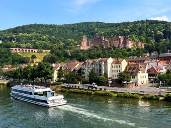 河上有一艘大型船 船对面是一座位于山丘上的城堡。