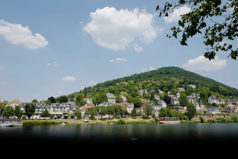 一个小村庄或山顶上的小镇 有船只停泊在水中 背景是山脉。