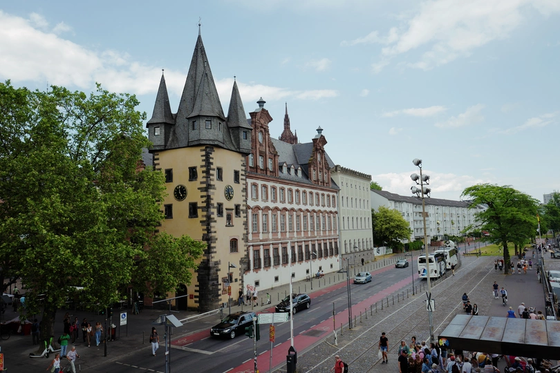 一条街道 两边有人们、汽车和大型建筑。