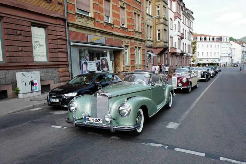 一条具有古老建筑的城市街道 一辆绿色汽车在公路上驶过。