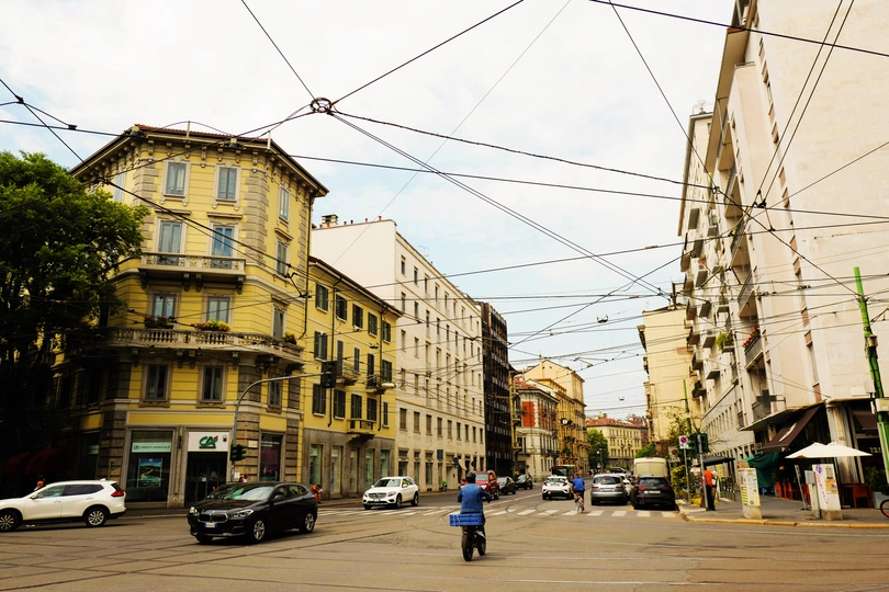 在一座拥有高楼大厦、汽车、行人和骑自行车的人的城市交叉口。