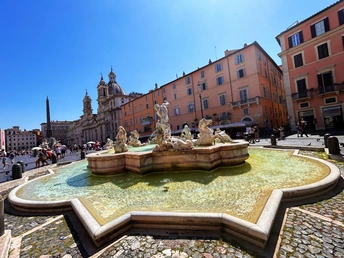 一个有喷泉的广场 背景中有人和建筑物。