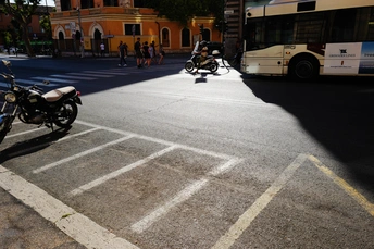 摩托车停在城市的街道旁边公交车站旁的停车场里