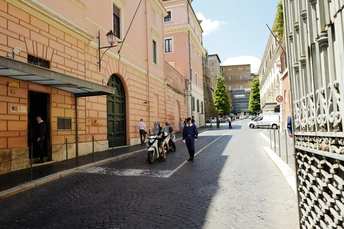 一条人行道上有骑滑板车的人和行走的人。