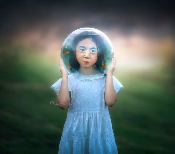 一个小女孩穿着白色连衣裙 举起双手捂住脸 在一个蓝色气泡中。