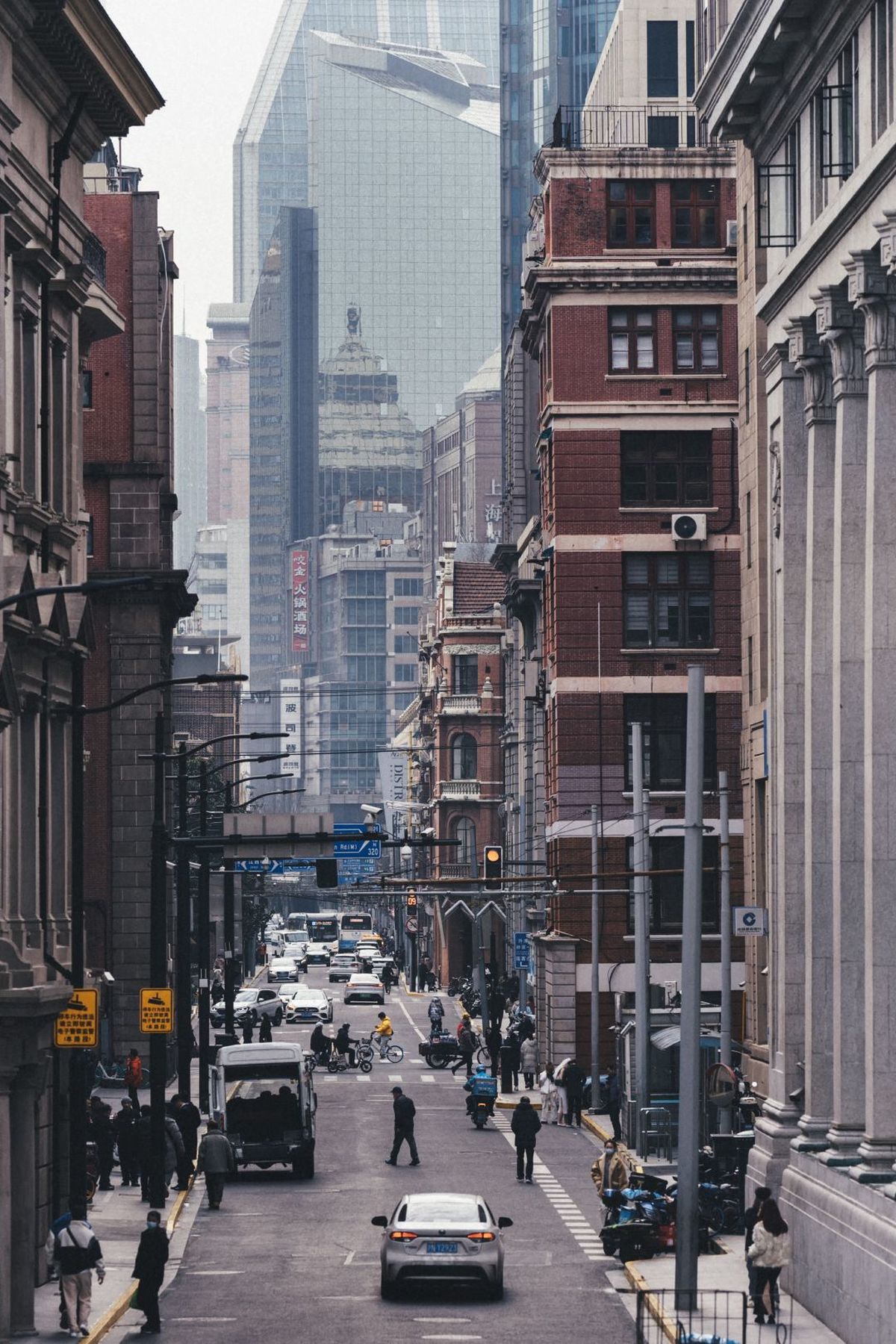 一条街道 有高楼、汽车、行人、人们。