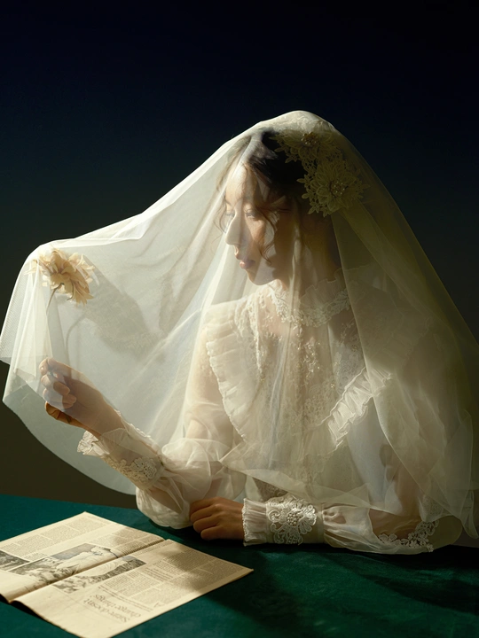 一个穿着白色婚纱和头纱的女人在桌子上