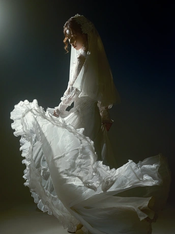 一个穿着白色婚纱的模特儿在黑暗中