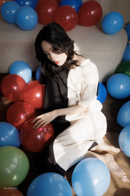 一个坐在红色和蓝色球环绕的沙发上的女人