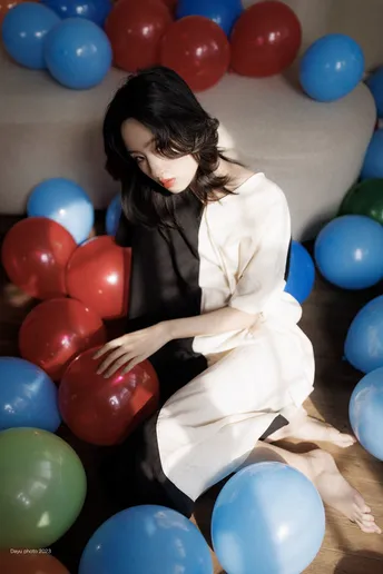 一个坐在红色和蓝色球环绕的沙发上的女人