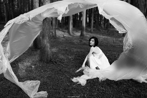 一张黑白照片 女孩穿着白色裙子在树林中