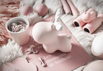 一个带有粉红色Hello Kitty床单和粉红色杯子的床。