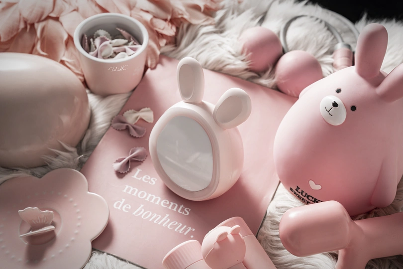 一个铺有粉色蛋糕和粉色Hello Kitty杯蛋糕的床