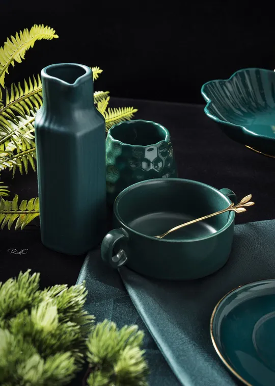 一个黑色桌子 上面有蓝色的盘子、一个盘子和一个碗。