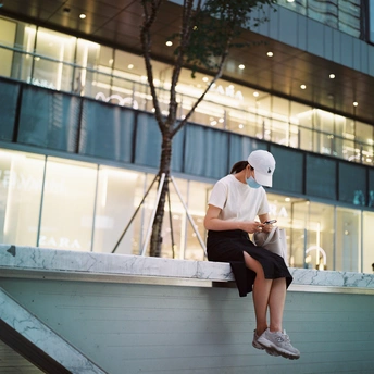 一个年轻女孩坐在建筑物边缘 一个男孩坐在墙上。