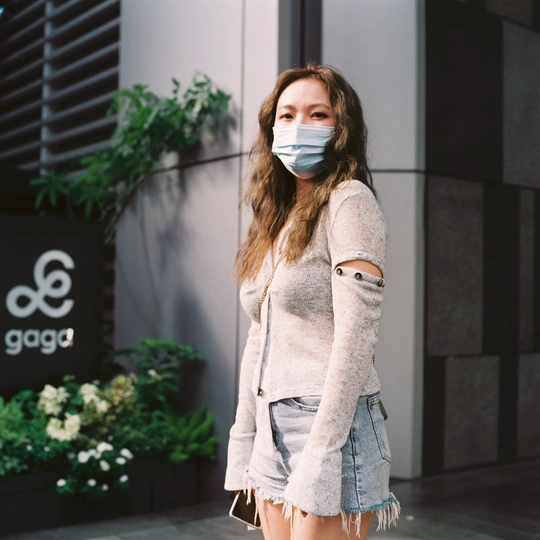 一位年轻女子戴口罩走在街上