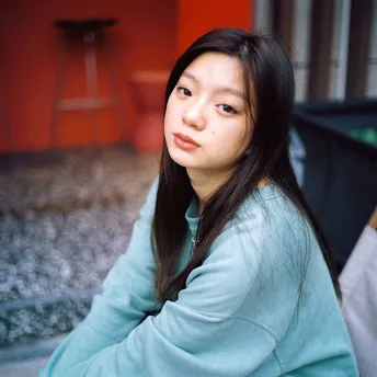 一位年轻女子坐在街道前方的红楼