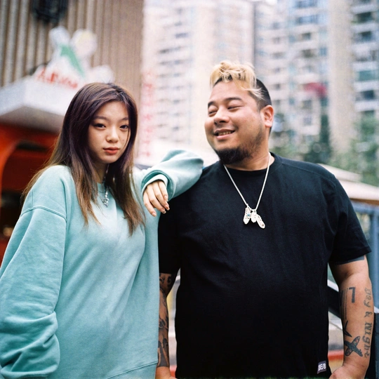 一位年轻男子和女子手牵手站在城市消防栓前 背景是高楼大厦。