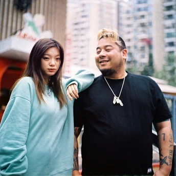 一位年轻男子和女子手牵手站在城市消防栓前 背景是高楼大厦。