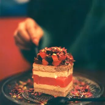一个人用叉子吃一个小甜点