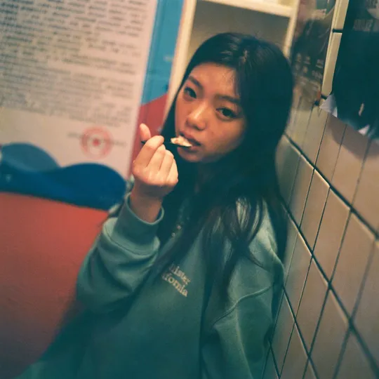 一位年轻女子站在浴室里刷牙