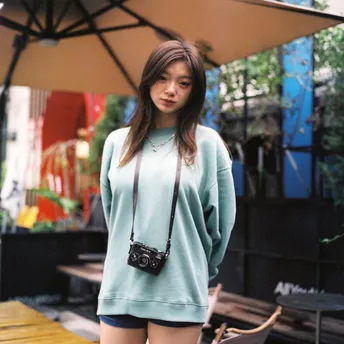 一个穿蓝色毛衣和过膝靴的女孩站在一把伞下
