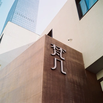 在一栋高楼前面有一个棕色标志。