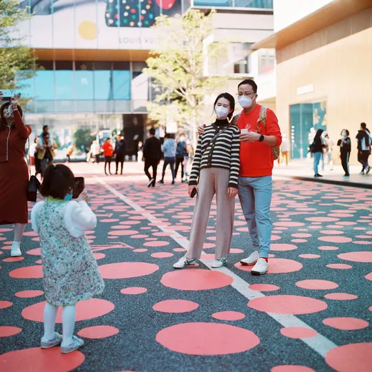 一位妇女和一个小女孩站在广场上 地板上有一个口罩。