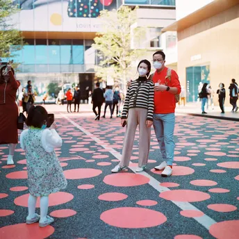 一位妇女和一个小女孩站在广场上 地板上有一个口罩。