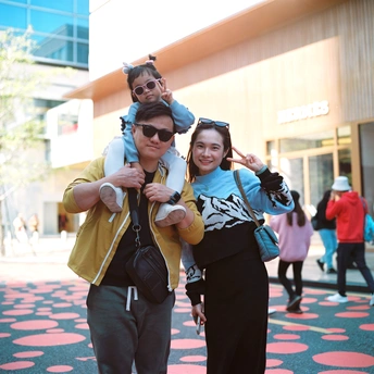 一个人抱着一个小孩站在街上拍照