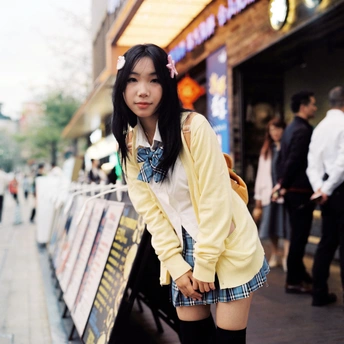 一位穿着黄色和高筒靴子的年轻女子在人行道上摆姿势
